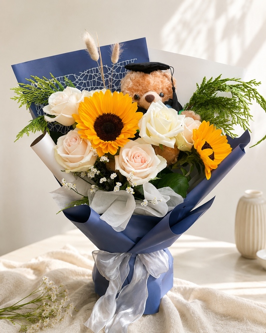 Graduation flower bouquet with sunflower, bear, white roses and blue wrapping